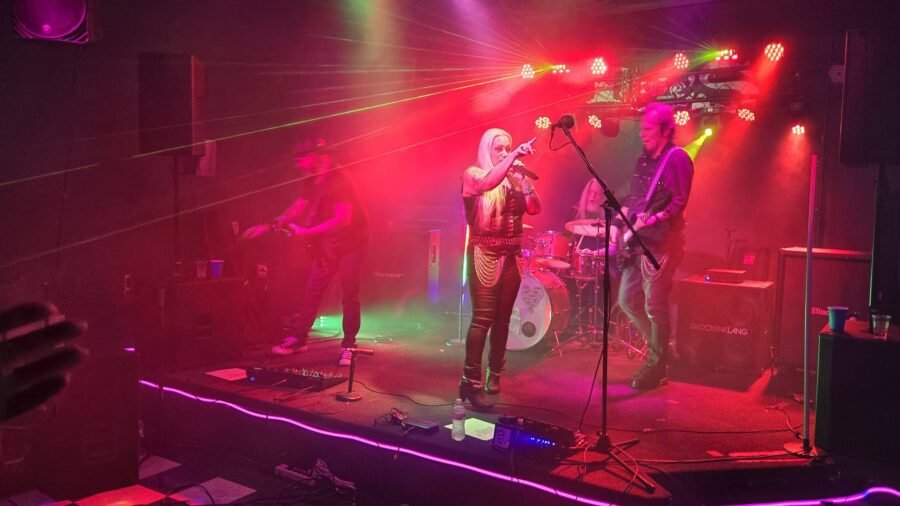 A band playing under stage lights