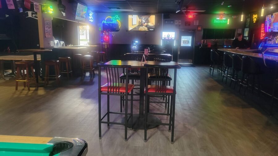 Tables, pool table and neon signs in the main room