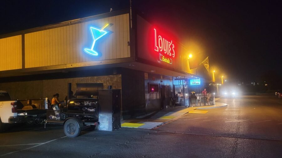 The neon martini glass and Louie's sign lit at night